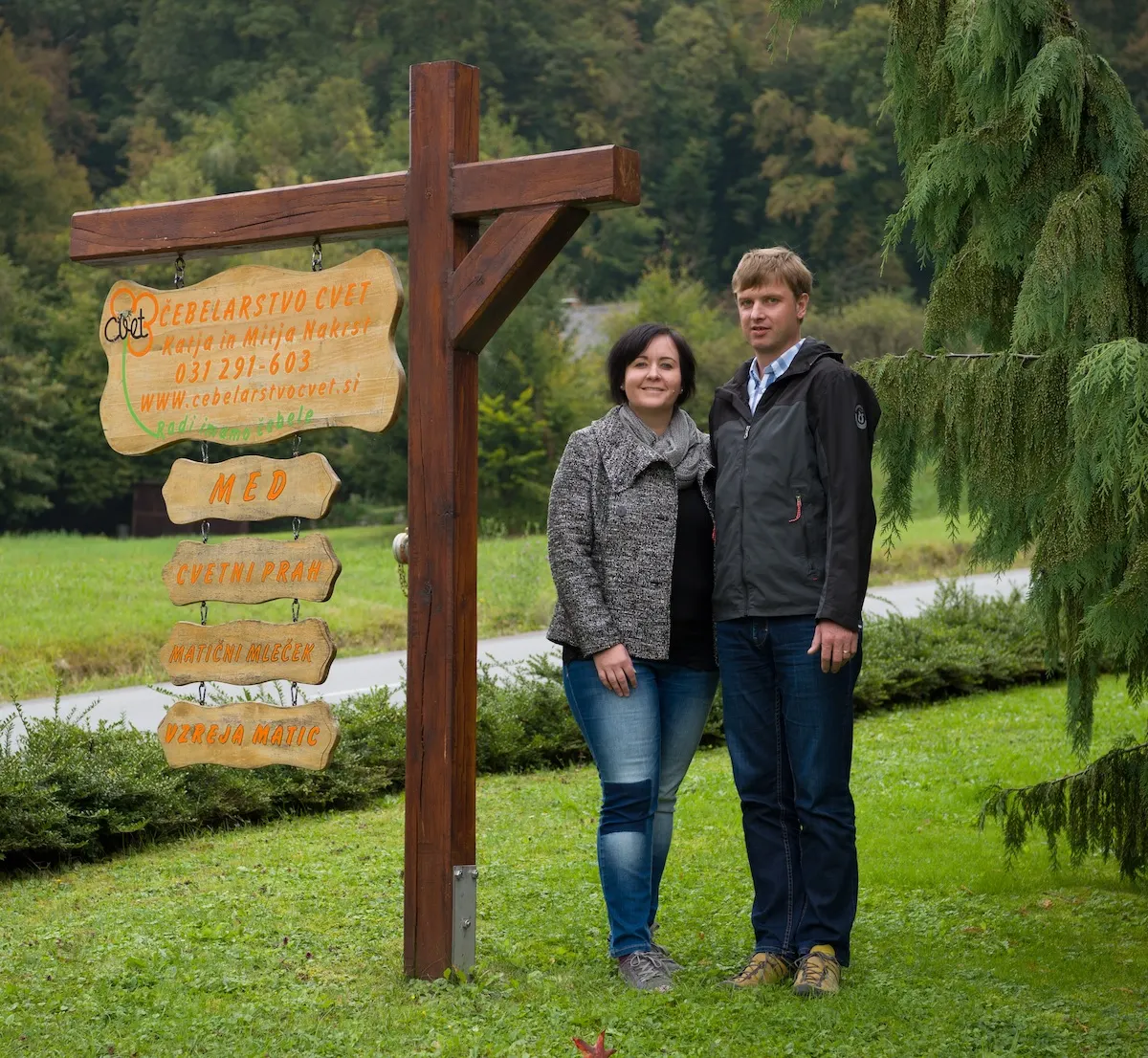 Katja in Mitja Nakrst ob lesenem usmerjevalnem znaku Čebelarstva Cvet